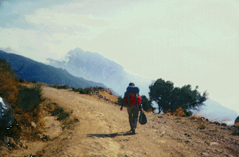 Anton walking with his backpack on a rough road